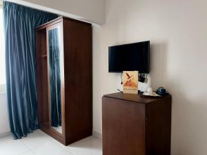 a room with a tv and a dresser with a window at New pyramids way in Cairo
