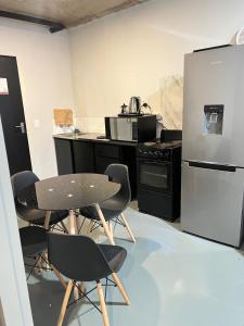 a kitchen with a table and chairs and a refrigerator at The eland in Johannesburg