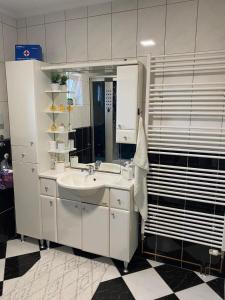 ein Badezimmer mit Waschbecken und Spiegel in der Unterkunft Apartman Vučedolski san in Vukovar + 13 Fotos