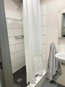 a white shower curtain in a bathroom with a sink at The eland in Johannesburg +2 photos