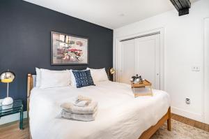 a bedroom with a large white bed with a black wall at The Saddlery - The Vault - 2 Min Walk to Broadway in Nashville