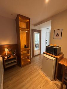a living room with a refrigerator and a microwave at Transamérica Executive Campos dos Goytacazes in Campos dos Goytacazes