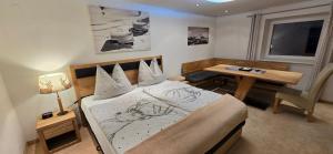 ein Schlafzimmer mit einem Bett, einem Tisch und einem Schreibtisch in der Unterkunft Exclusive Appartement Chalet in Sankt Johann in Tirol