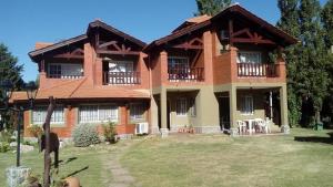 a large brick house with a large yard at Posada Los Alamos in Merlo