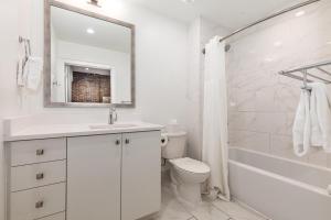 Un baño blanco con lavabo e inodoro. en The Saddlery-Tracklist-2 Units-Walk to Broadway, en Nashville 72 fotos más