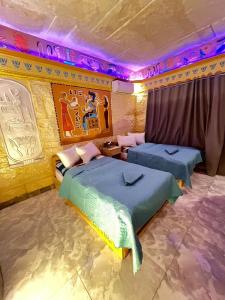 2 letti in una camera con luci viola di Pyramids Mystery Inn a Il Cairo