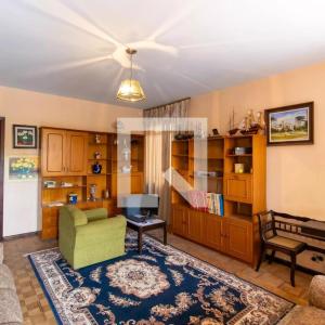 a living room with a green chair and a couch at Apartamento 04 old no Capão da Imbuia in Curitiba