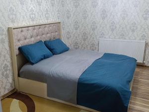 a bed with blue pillows in a bedroom at Nakhchivan Family Home in Naxçıvan