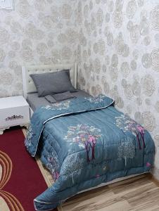 a bedroom with a bed with a blue blanket at Nakhchivan Family Home in Naxçıvan