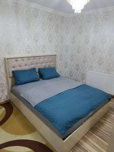 a bed with two blue pillows in a bedroom at Nakhchivan Family Home in Naxçıvan