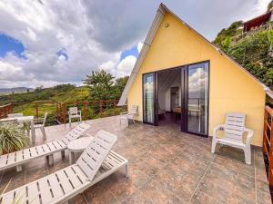 a patio with white chairs and tables and a building at Finca Hotel Los Guayacanes in San JosÃ© +21 photos