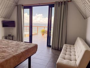 a bedroom with a bed and a view of a balcony at Finca Hotel Los Guayacanes in San JosÃ©