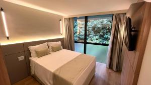 a bedroom with a bed and a large window at Life Residence in Belo Horizonte