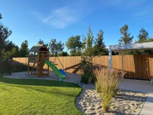 une aire de jeux avec un toboggan et un belvédère dans l'établissement Comfortable, convenient holiday apartment, à Grzybowo