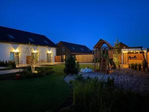 une maison avec une aire de jeux dans la cour la nuit dans l'établissement Comfortable, convenient holiday apartment, à Grzybowo