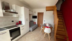 a small kitchen with a table and a dining room at Casa Di Gloria in Perledo