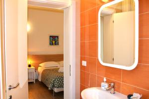 a bathroom with a sink and a mirror and a bed at My Bnb Pisa in Pisa