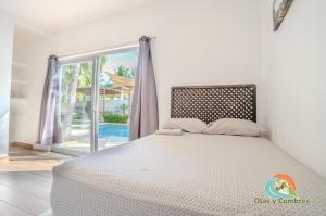 TaxiscoVilla Los Delfines 1的一间卧室，里面有一张床和一扇大窗户。