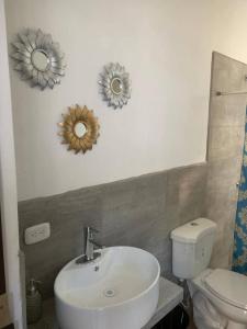 TaxiscoVilla Los Delfines 1的一间带水槽、卫生间和镜子的浴室