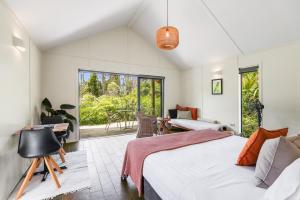 a bedroom with a bed and a living room at The Hideout in Mangawhai