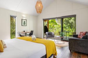 a bedroom with a bed and a living room at The Hideout in Mangawhai