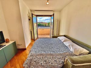 ein großes Bett in einem Zimmer mit einem großen Fenster in der Unterkunft Appartamento con posto auto riservato tra spiaggia, centro, stazione ed ospedale in Pescara