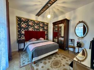 une chambre avec un lit et un miroir dans l'établissement Le Manoir du Bonheur, à Chaumes-en-Brie 58 autres photos