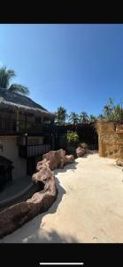 ein Gebäude mit einigen Steinen im Sand in der Unterkunft La libélula hotel in San Pedro Pochutla