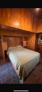 ein großes Bett in einem Zimmer mit Holzwänden in der Unterkunft La libélula hotel in San Pedro Pochutla