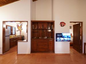 eine Küche mit Holzschränken und einem Fernseher an der Wand in der Unterkunft Villa silenziosa e sicura al centro di Las Galeras in Las Galeras