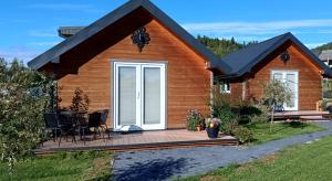 a cabin with a wooden deck in front of it at Spiska Dolina in Łapsze Niżne