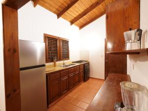 eine Küche mit Holzschränken und einem Edelstahlkühlschrank in der Unterkunft Villa silenziosa e sicura al centro di Las Galeras in Las Galeras + 42 Fotos