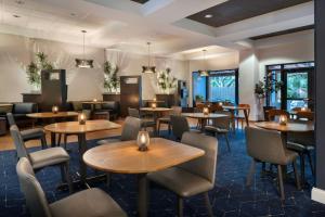 a restaurant with tables and chairs in a room at Courtyard by Marriott Cocoa Beach Cape Canaveral in Cocoa Beach