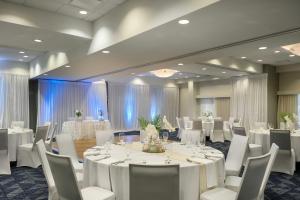 a banquet room with white tables and white chairs at Courtyard by Marriott Cocoa Beach Cape Canaveral in Cocoa Beach +79 photos
