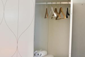 a closet with a surfboard and hangers at The Green Gate - Airport Guest House in Pisa