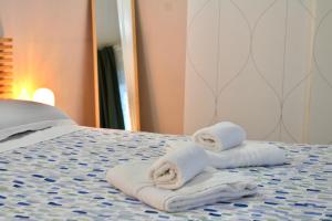 two towels sitting on top of a bed at The Green Gate - Airport Guest House in Pisa