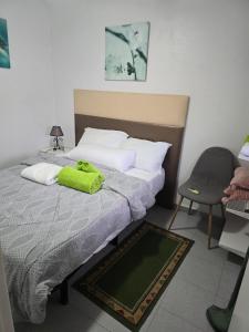een slaapkamer met een bed met een groene handdoek erop bij LOS1-VAO Holiday Rentals- Los Alcazares near Roda Roundabout in Los Alcázares