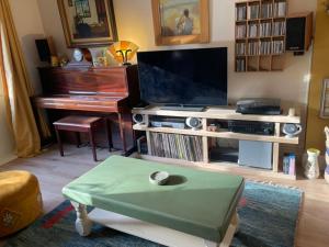 sala de estar con TV y piano en Crispins Corner, en Stedham