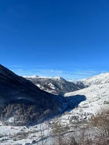 a view of a snow covered mountain with a river at Rifugio delle Emozioni in Grange Sises +5 photos