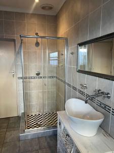 a bathroom with a sink and a shower at Ridah's Accomodation in Bellville +38 photos