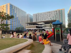 a group of people sitting around a playground in a city at Cheapest Staycation at the Metro in Manila