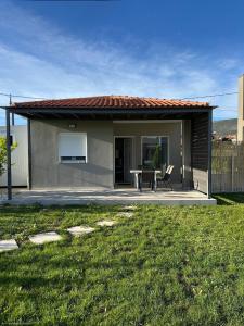 ein kleines Haus mit einem Tisch und Stühlen im Hof in der Unterkunft Taras Studio in Karavádhos