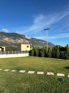 a grassy field with a building and mountains in the background at Taras Studio in Karavádhos
