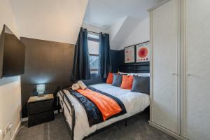 - une chambre dotée d'un lit avec des oreillers orange et bleu dans l'établissement Fraserburgh Apartment - 2 bed, free parking & wifi, à Fraserburgh
