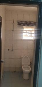 Un pequeño baño con inodoro y ventana. en ED Apartment, en Mama 2 fotos más