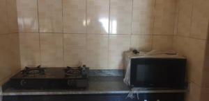 cocina con fogones y TV en una habitación en ED Apartment, en Mama