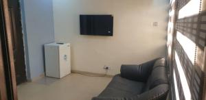 a living room with a couch and a television on a wall at ED Apartment in Mama