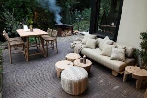 a patio with a couch and tables and a grill at Homestorys Nature Resort in Eupen