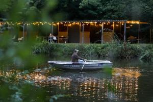 a man is rowing a boat on the water at Homestorys Nature Resort in Eupen