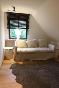a white couch in a room with a window at Homestorys Nature Resort in Eupen +47 photos